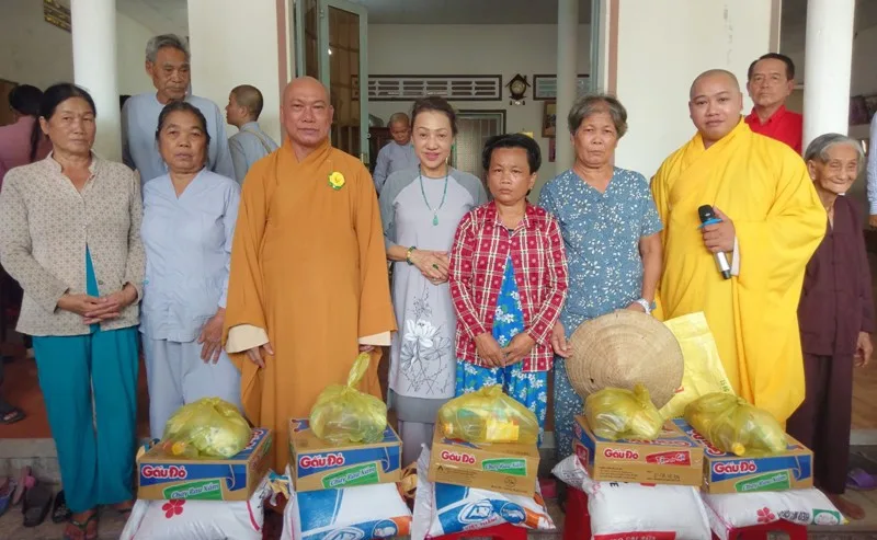Đại diện hội từ thiện chùa Bát Nhã tặng quà cho bà con khó khăn